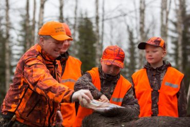 Oranssiin pukeutuneita metsästäjiä.