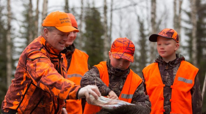 Oranssiin pukeutuneita metsästäjiä.