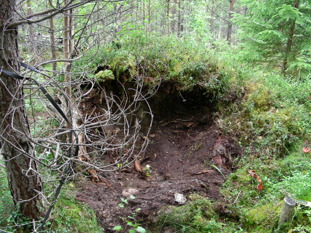 Päivämakuupaikka metsässä, varvikon keskelle töyrääseen kaivettu maapohjainen makuupaikka.