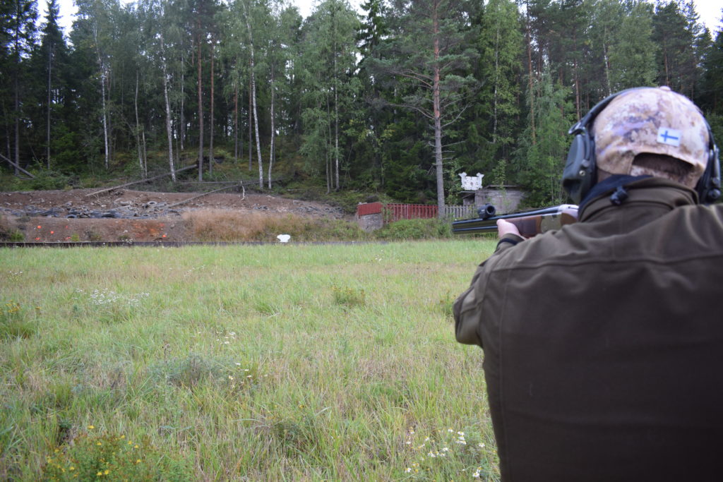 Utbildaren övervakar lärlingens hagelskytte på skjutbanan.