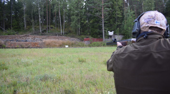 Utbildaren övervakar lärlingens hagelskytte på skjutbanan.