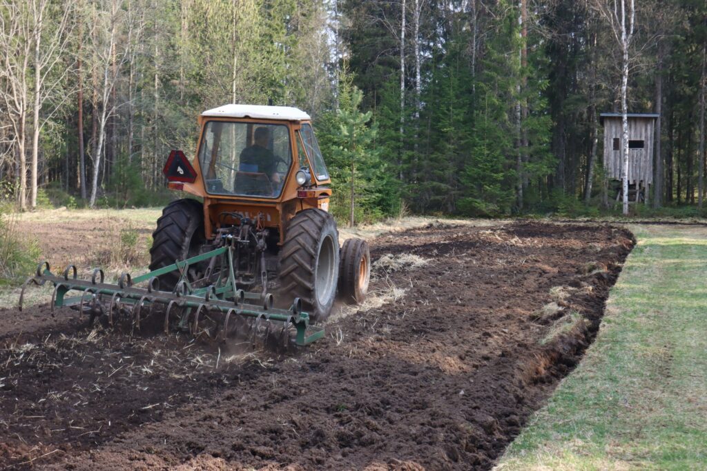 Riistapeltoa äestetään traktorilla.