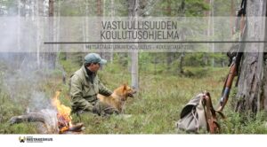 Koulutusmateriaalin kansikuva, kuvassa on metsästäjä koiransa kanssa tulilla metsässä.
