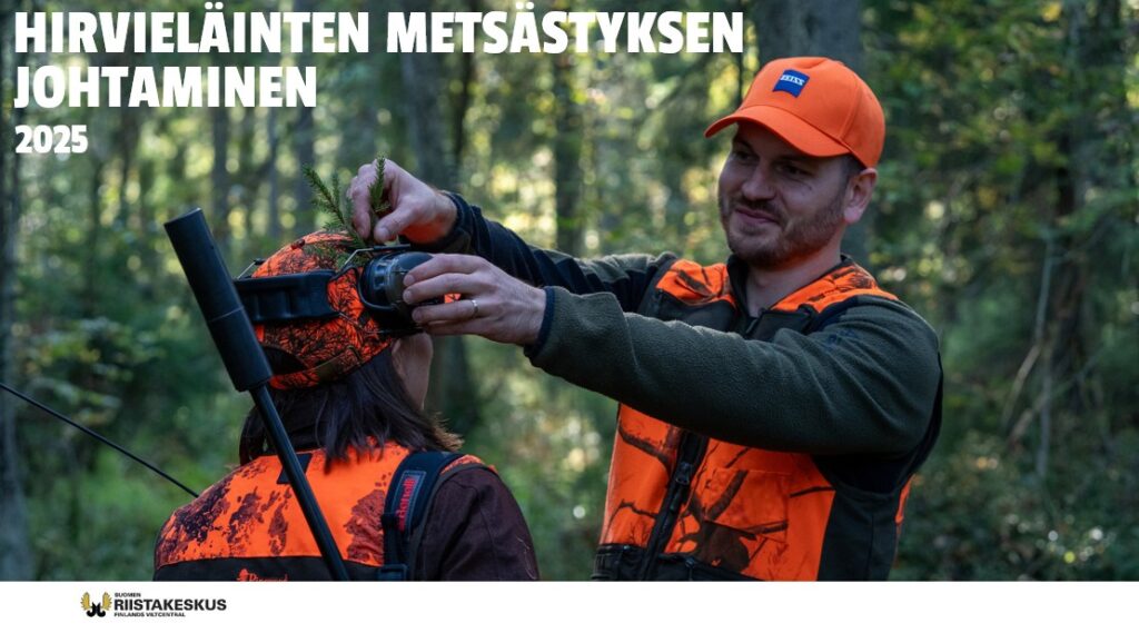 Metsästyksenjohtaja asettaa havua toisen metsästäjän lakkiin kaadon merkiksi.
